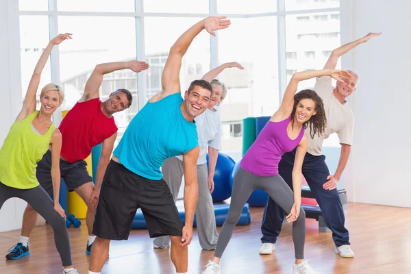Ταιριάζει άνθρωποι κάνουν τέντωμα άσκηση στο γυμναστήριο — Φωτογραφία Αρχείου
