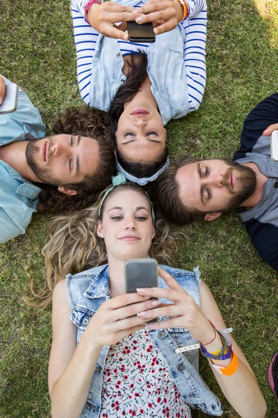 Happy vrienden liggen op het gras — Stockfoto