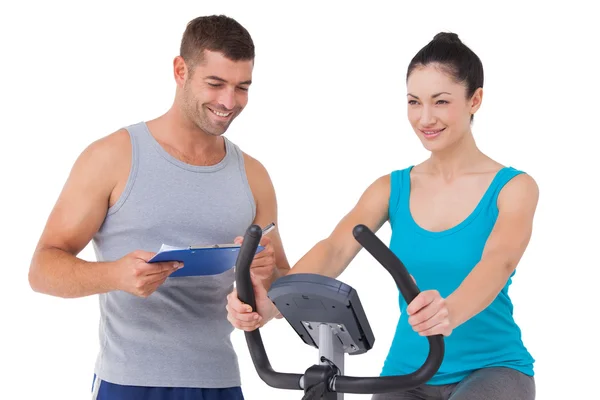 Trainer with client on exercise bike — Stock Photo, Image