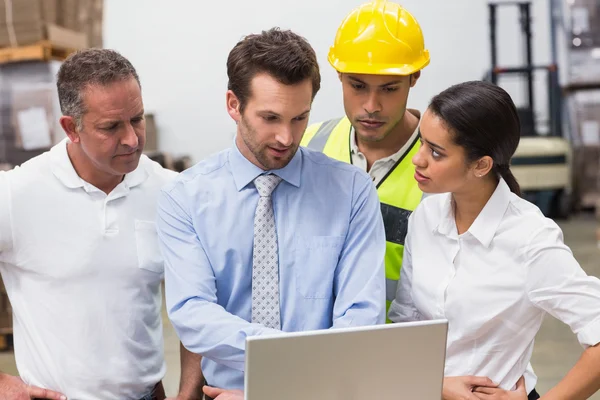 Gestori di magazzino e lavoratori che guardano laptop — Foto Stock