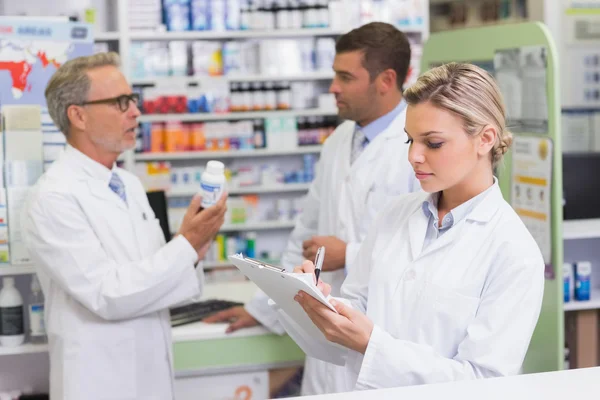 Focused pharmacist writing on clipboard — Stock Photo, Image