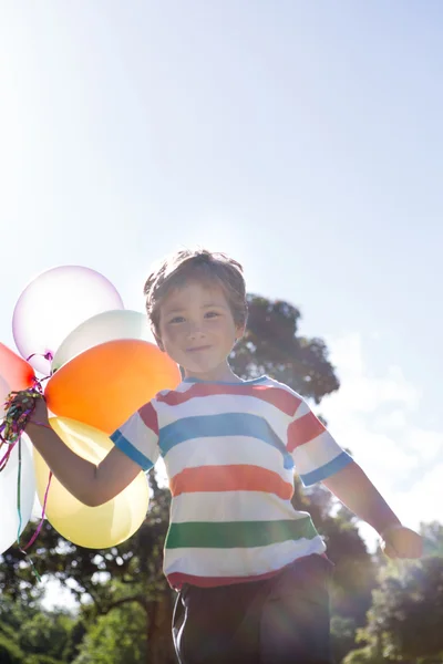Liten pojke innehav ballonger — Stockfoto