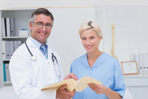 Zufriedene Ärztin und Krankenschwester halten Bericht — Stockfoto