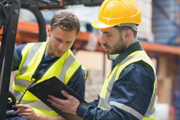 Focused warehouse workers talking together — Stock Photo, Image