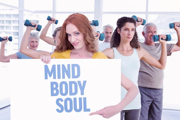 Redhead showing a poster against mind body soul — Stock Photo, Image