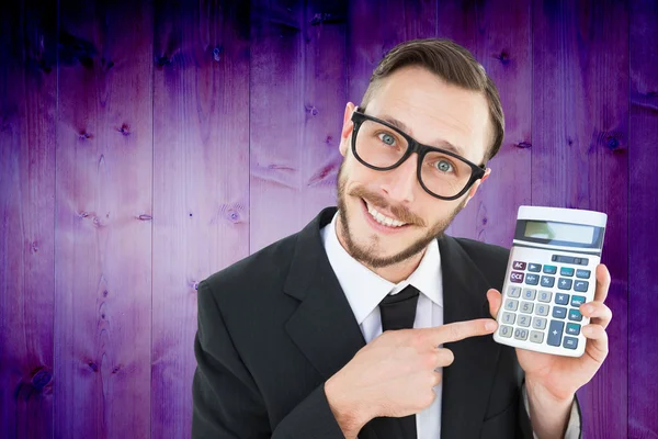 Geeky businessman pointing to calculator — Stock Photo, Image