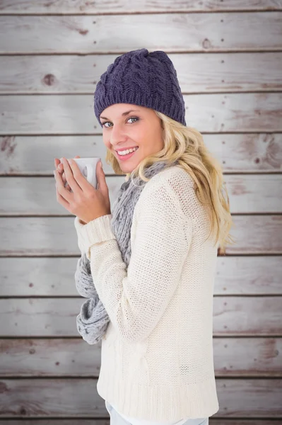 Блондинка в зимней моде держа кружку — стоковое фото