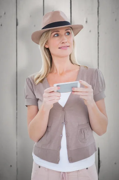 Šťastný blondýna v plstěný klobouk drží telefon — Stock fotografie