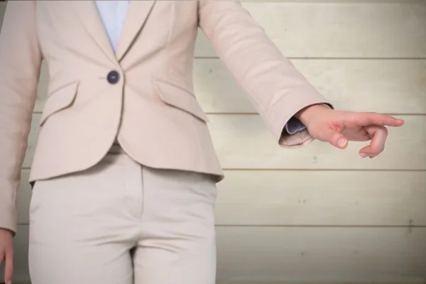 Businesswoman pointing against wooden planks — Stock Photo, Image