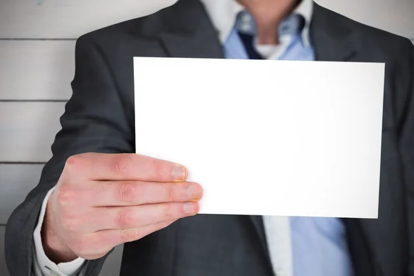 Empresário em terno cinza mostrando cartão — Fotografia de Stock