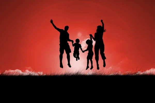 Silhouette de famille sautant contre le ciel rouge — Photo