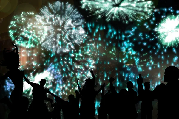 Silhouettes of cheering people against fireworks — Stock Photo, Image