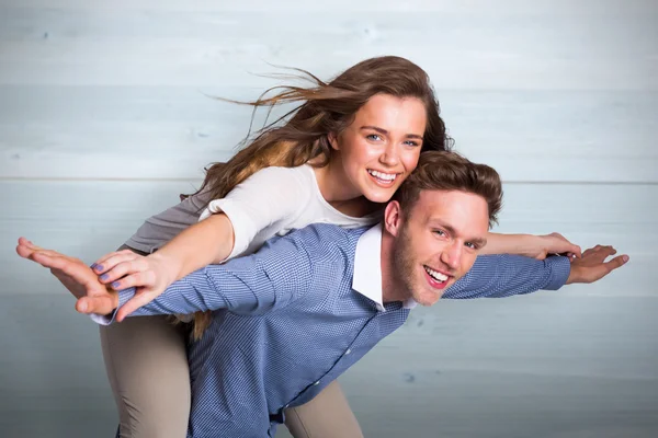 Smiling young man carrying woman — Stock Photo, Image