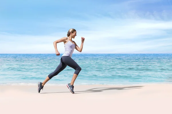 Fit blonde jogging contre plage scène — Photo