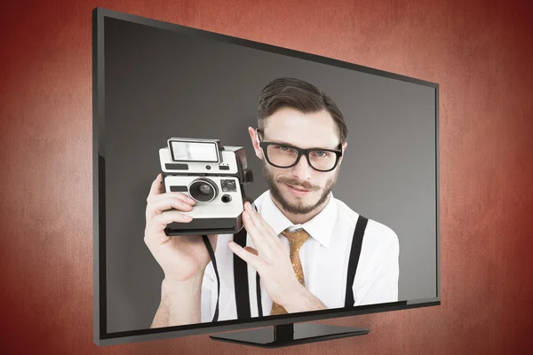 Geeky hipster holding a retro camera — Stock Photo, Image