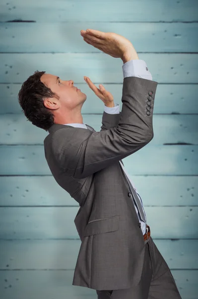 Businessman standing with arms pressing up — Stock Photo, Image