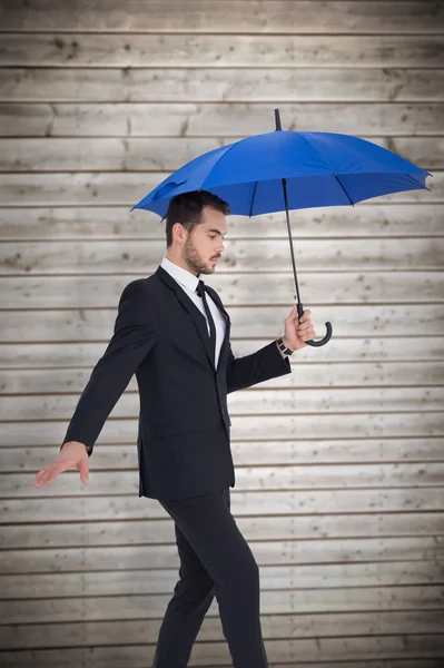 Концентрированный бизнесмен держит зонтик — стоковое фото