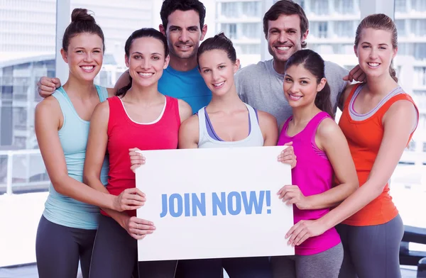 Join now! against fit smiling people holding blank board — Stock Photo, Image