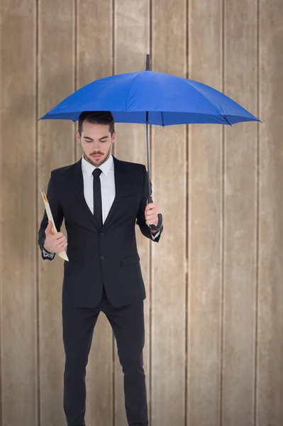 Dosya bir mavi şemsiyesi altında tutan işadamı — Stok fotoğraf