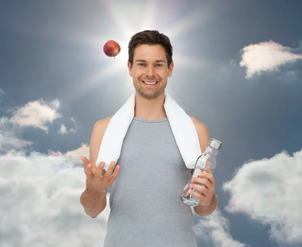 Young man with apple and water bottle — Stock Photo, Image