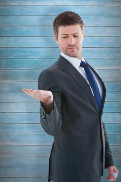 Businessman holding hand out in presentation — Stock Photo, Image