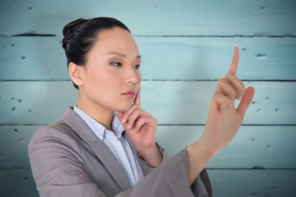 Pensativo asiático mujer de negocios señalando — Foto de Stock