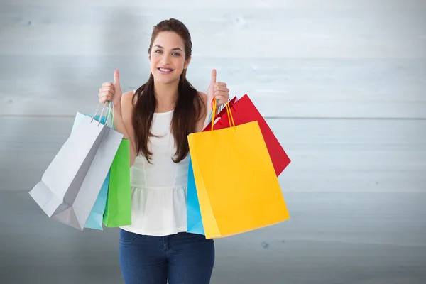 Morena sosteniendo bolsas con pulgares hacia arriba —  Fotos de Stock