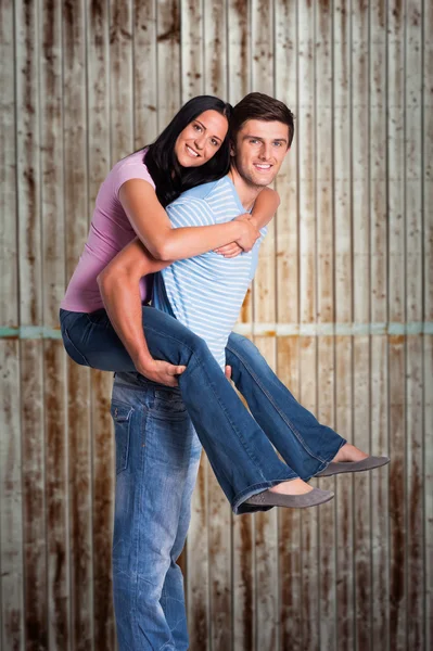 Człowieka, dając dziewczyna przejażdżkę piggyback — Zdjęcie stockowe