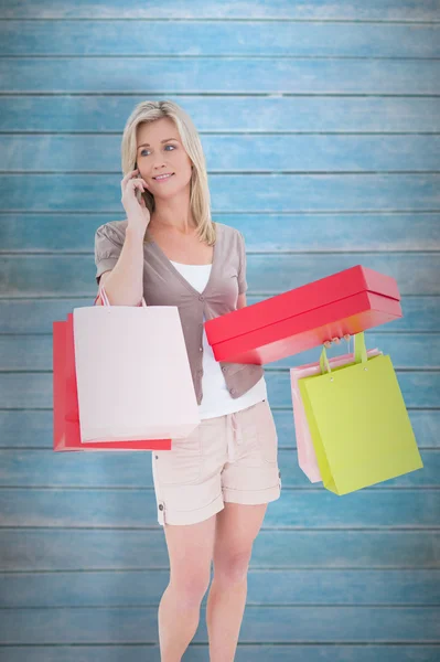 Rubia con bolsas de compras en el teléfono —  Fotos de Stock