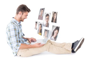 Handsome young man sitting using laptop clipart