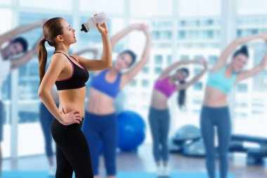 Fit brunette drinking from sports bottle clipart