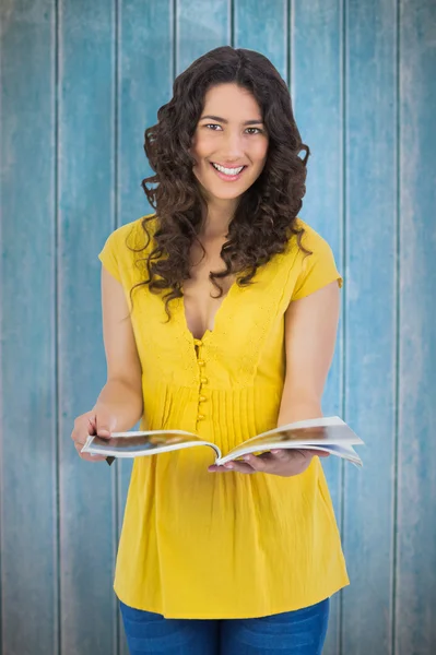 Kręcone włosy brunetka czytania magazynu — Zdjęcie stockowe