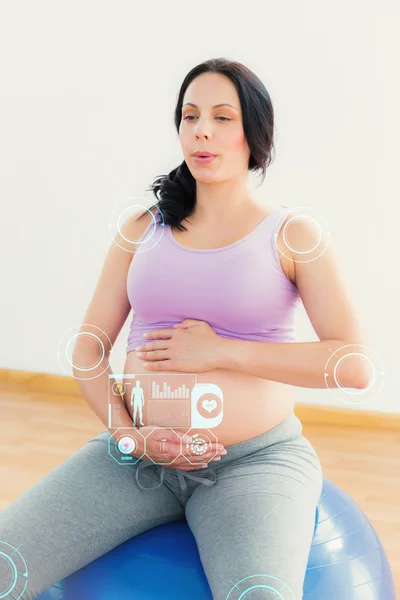Brune enceinte assise sur un ballon d'exercice — Photo