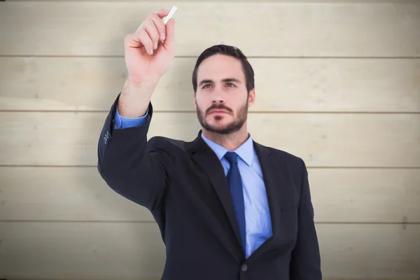 Businessman holding chalk and writing — Stock Photo, Image