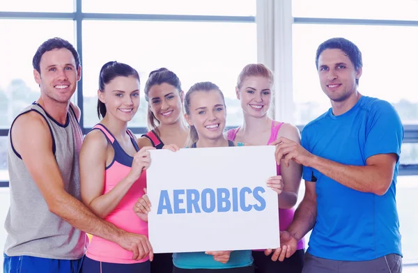 Aerobics against portrait of a group of fitness class holding bl — Stock Photo, Image