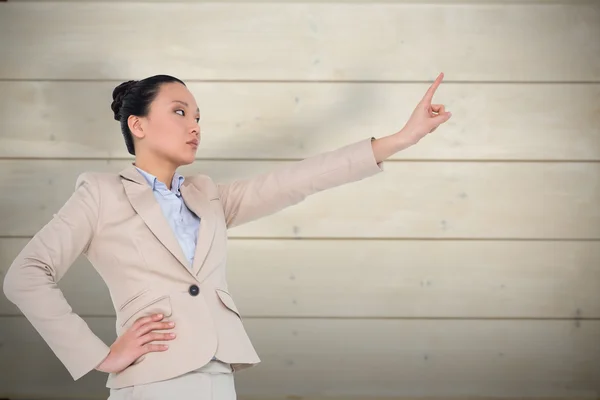 Unsmiling asian businesswoman pointing — Stock Photo, Image