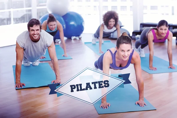 Word pilates and people doing push ups in fitness studio — Stock Photo, Image