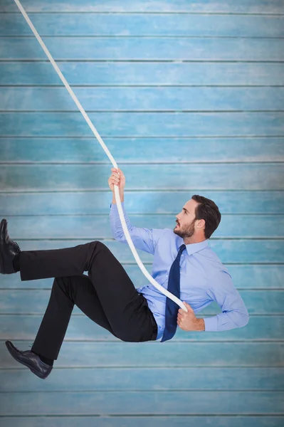 Businessman pulling a rope with effort — Stock Photo, Image