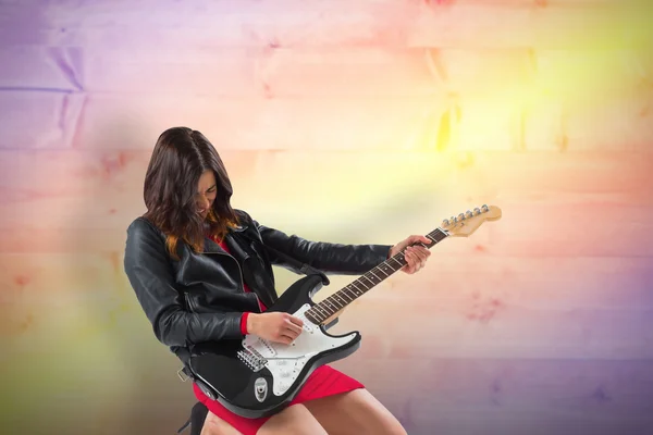 Brunette in biker jacket playing guitar — Stock Photo, Image