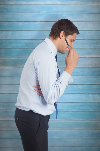 Thinking businessman holding pen — Stock Photo, Image