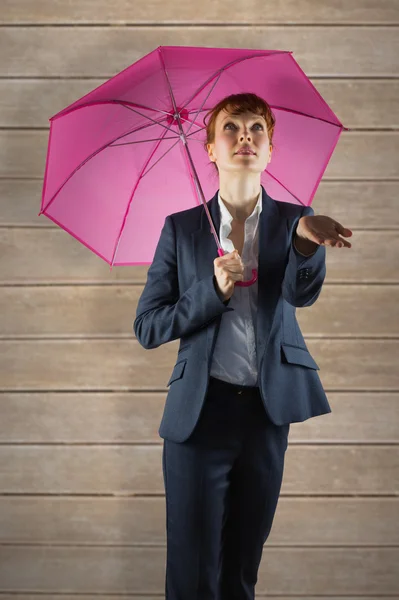 Businesswoman with umbrella against wooden planks — Stock Photo, Image