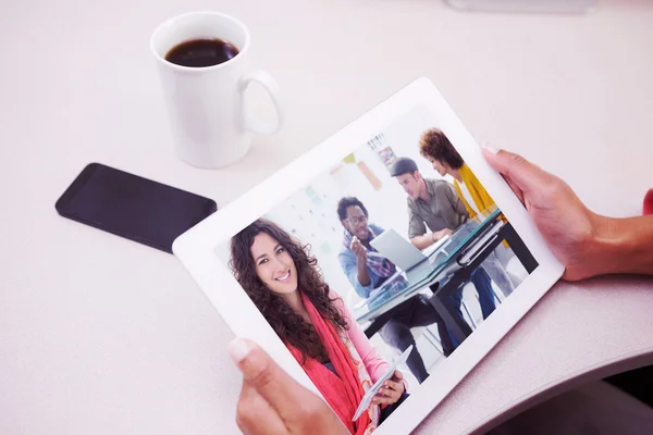 Imagen compuesta del diseñador sonriente usando tableta —  Fotos de Stock