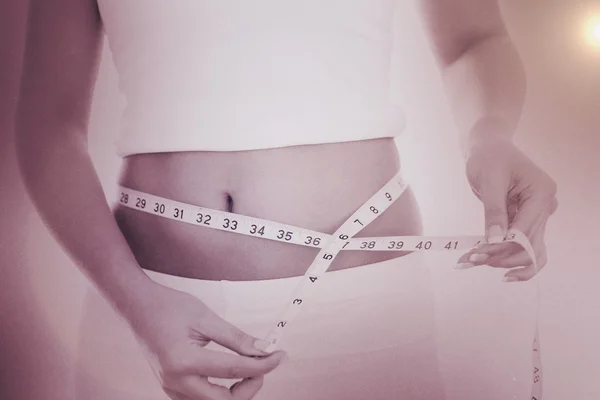 Midsection of woman measuring waist — Stock Photo, Image