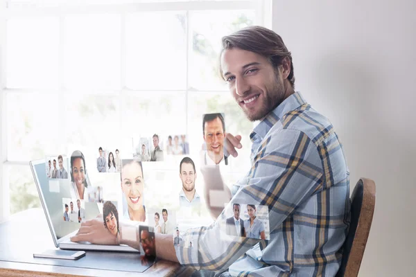 Bonito homem sentado à mesa usando laptop — Fotografia de Stock