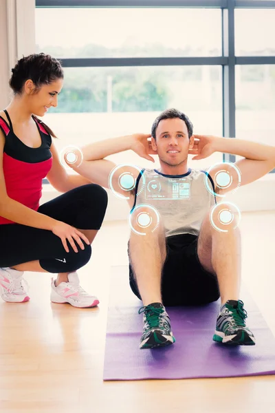 Female trainer watching man do abdominal crunches — Stock Photo, Image