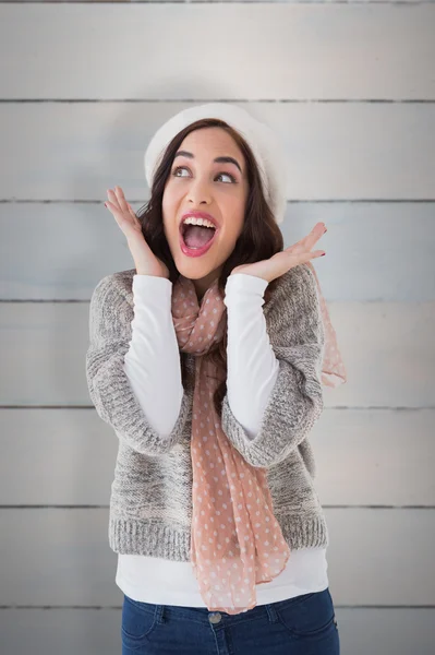 Verbaasd brunette tegen houten planken — Stockfoto