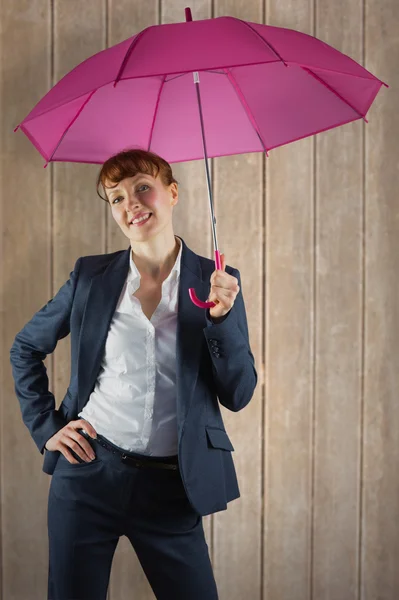 Бизнесмен с зонтиком на деревянной поверхности — стоковое фото