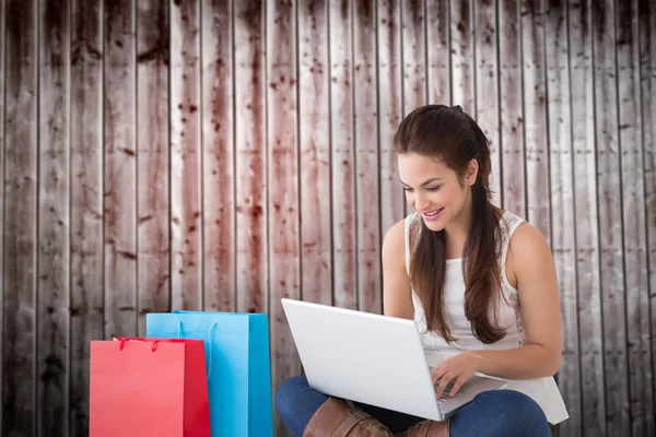 Brunett sitter och använder sin laptop — Stockfoto