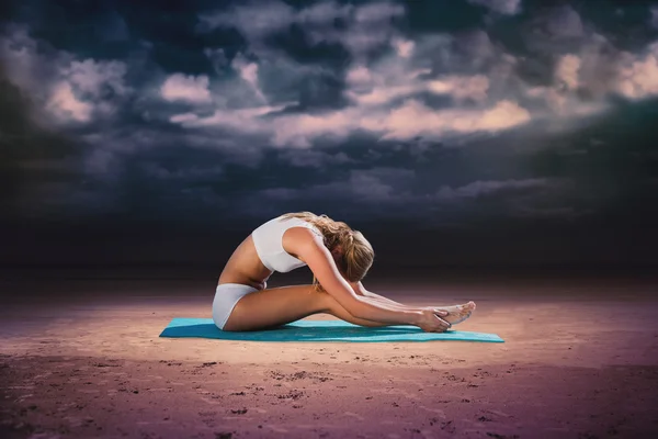 Blondin i sittande framåt krökning pose — Stockfoto