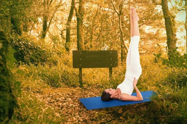 Woman stretching body against autumn forest — Stock Photo, Image